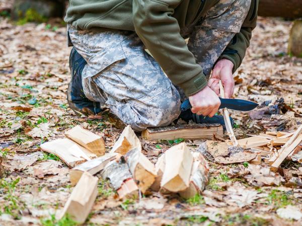 Man carving wood for campfire