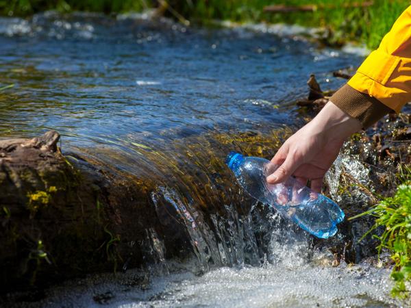 Man collecting water from stream