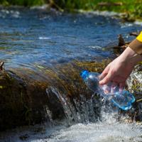 Man collecting water from stream